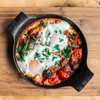 Free photo closeup of traditional shakshuka in a frying pan on a wooden background